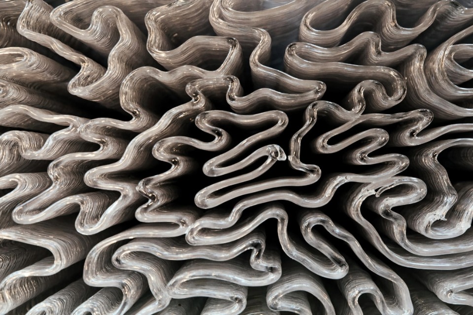 Close-up of folded, wavy sheet material creating an abstract, organic pattern.