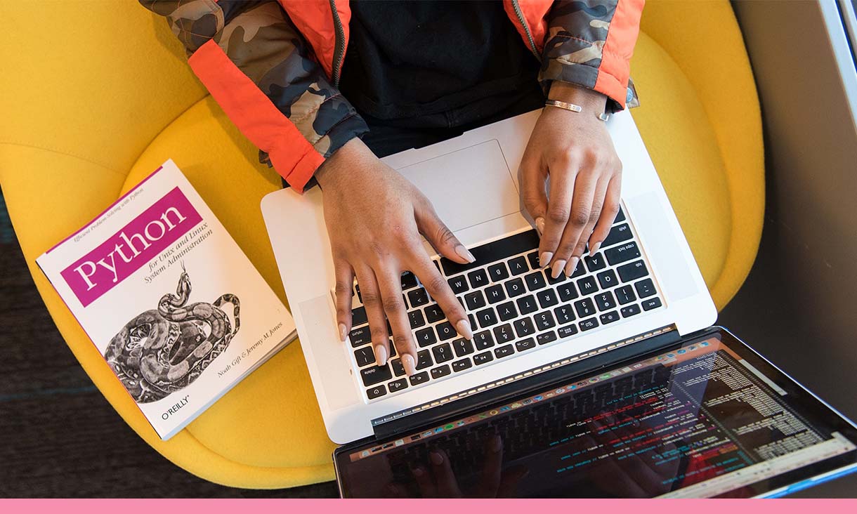 Birds eye view of a person typing code on their laptop.