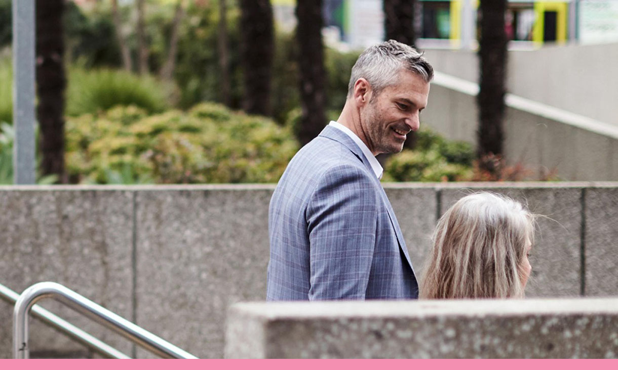 Two people walk down exterior stairs.