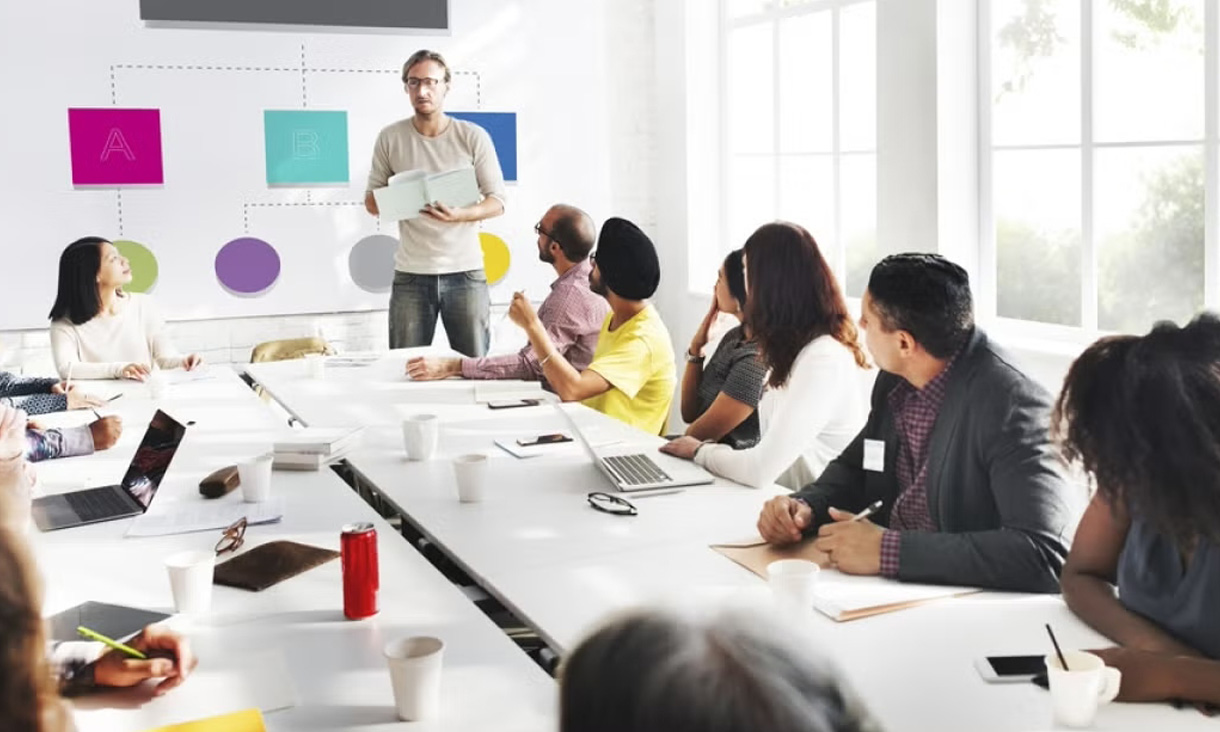 A project manager presents to his team in a meeting room.
