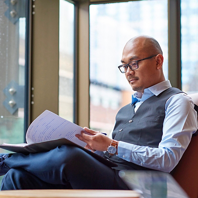 Man sitting and reading from a notebook